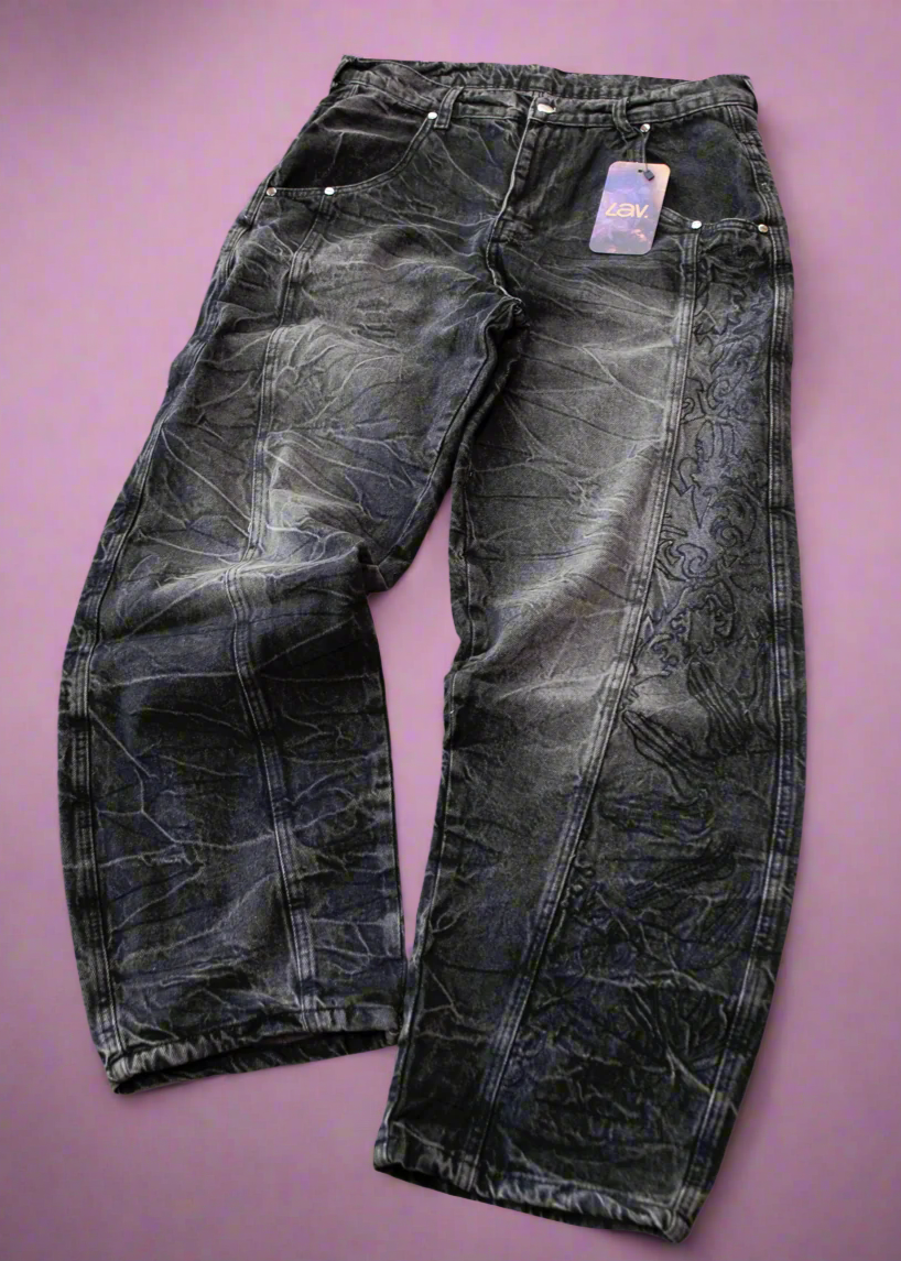 A pair of black denim jeans with full-length embroidery displayed against a purple background.