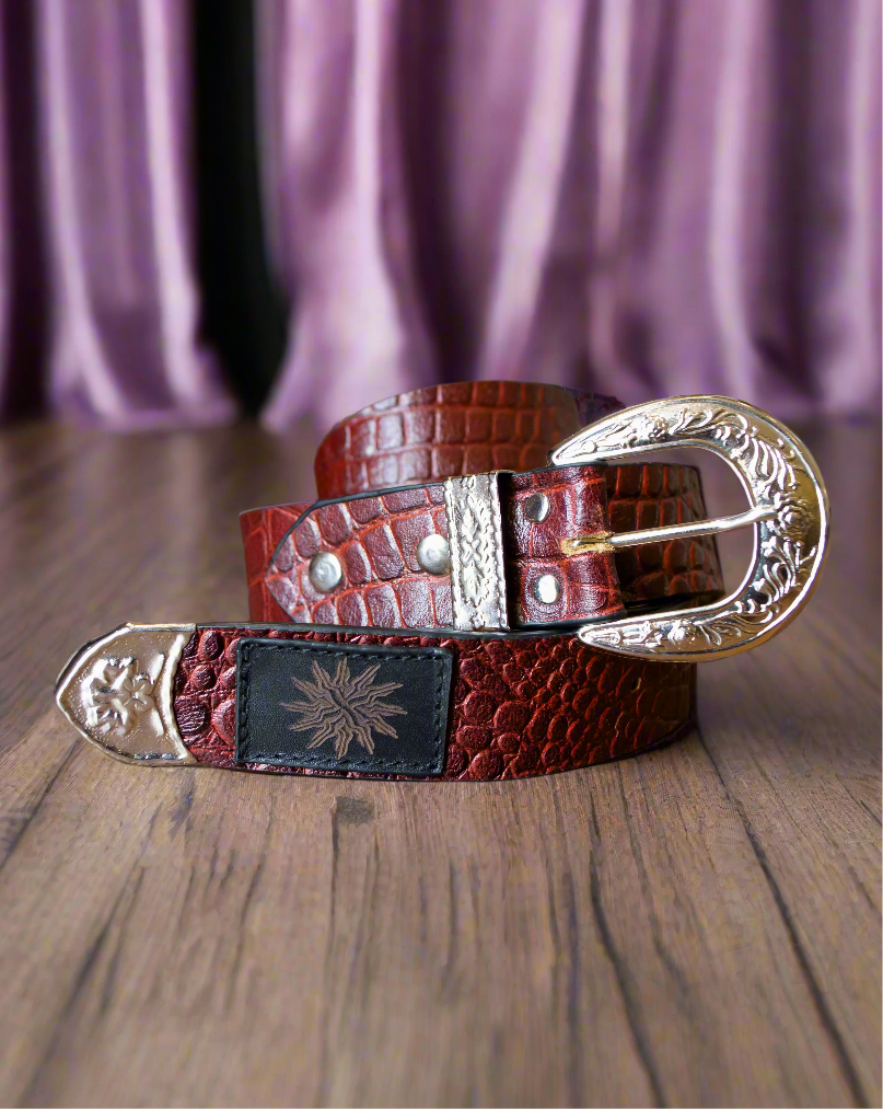 A brown belt with detailed silver hardware, displayed on a wooden surface.